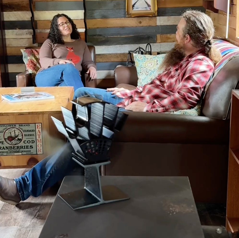 A couple relaxing by their wood burner with the Breezy Stove fan running